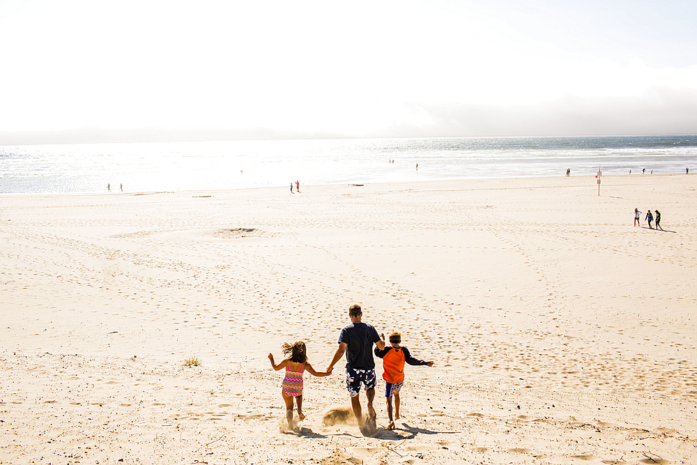 Caucasian family walking on beach