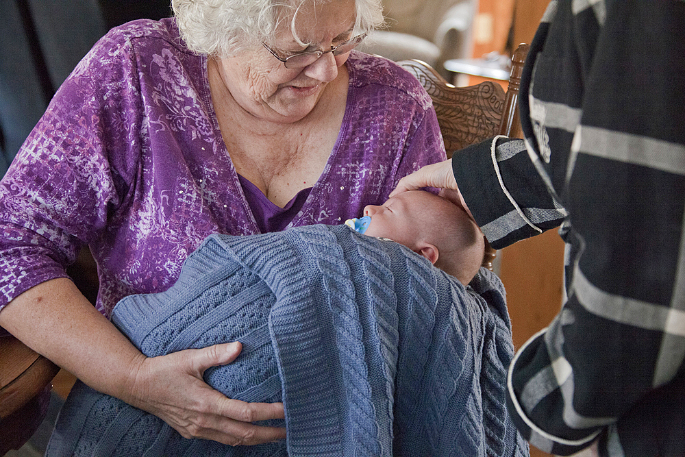 Caucasian grandmother holding baby grandson