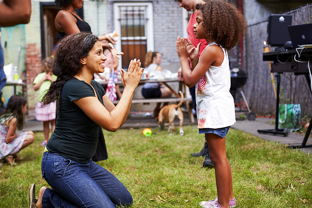 Mixed Race mother and daughter playing clapping game