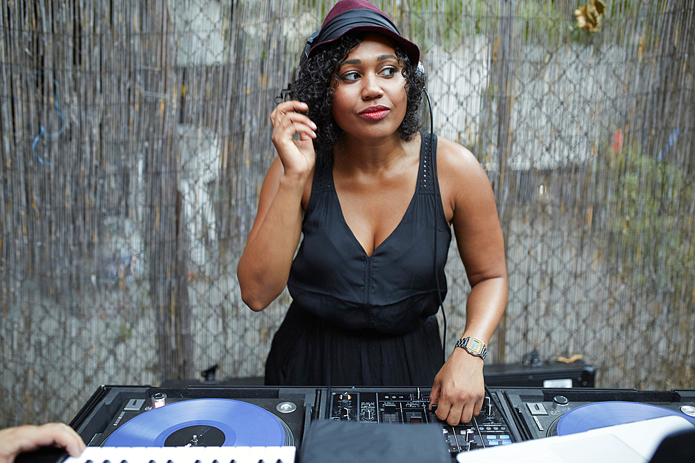 Mixed Race dj playing music in backyard