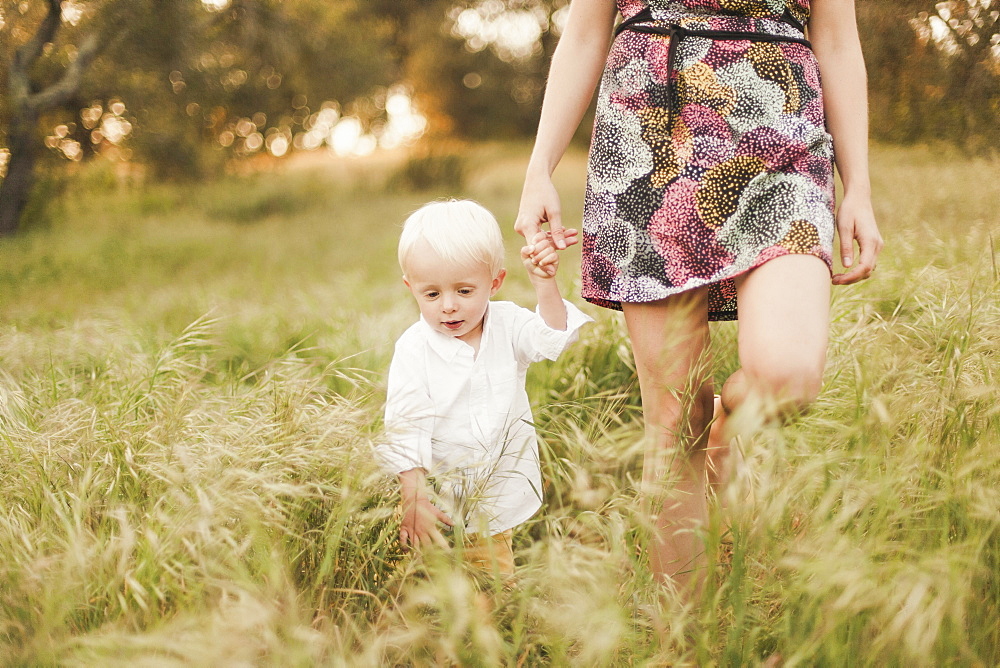 Mother and son walking in field