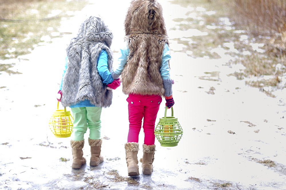 Caucasian girls holding hands in snow