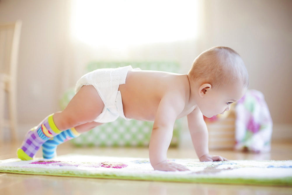 Mixed race baby girl playing on floor