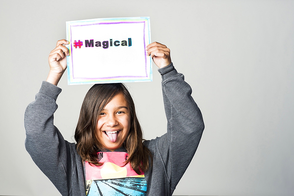 Hispanic girl holding magical sign above head