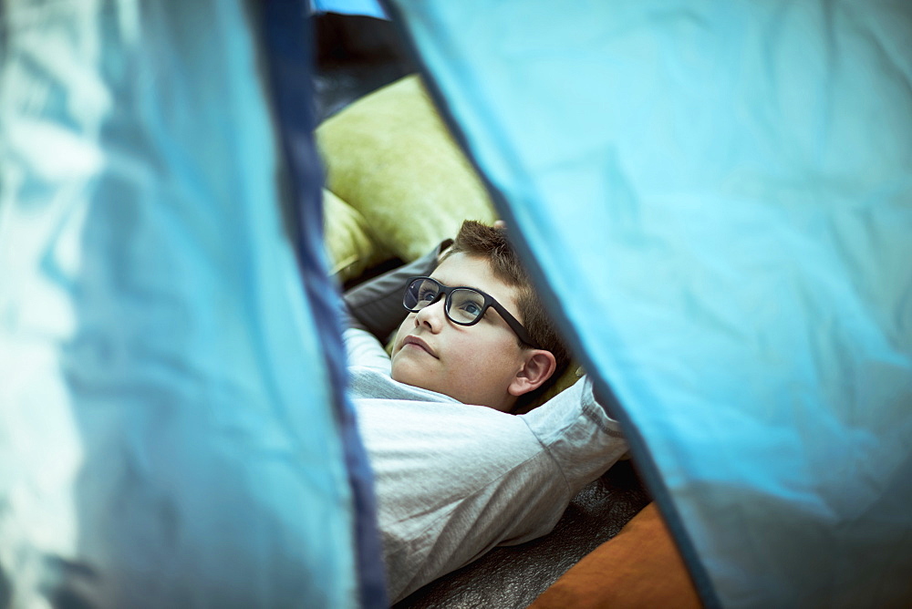 Hispanic boy camping in tent