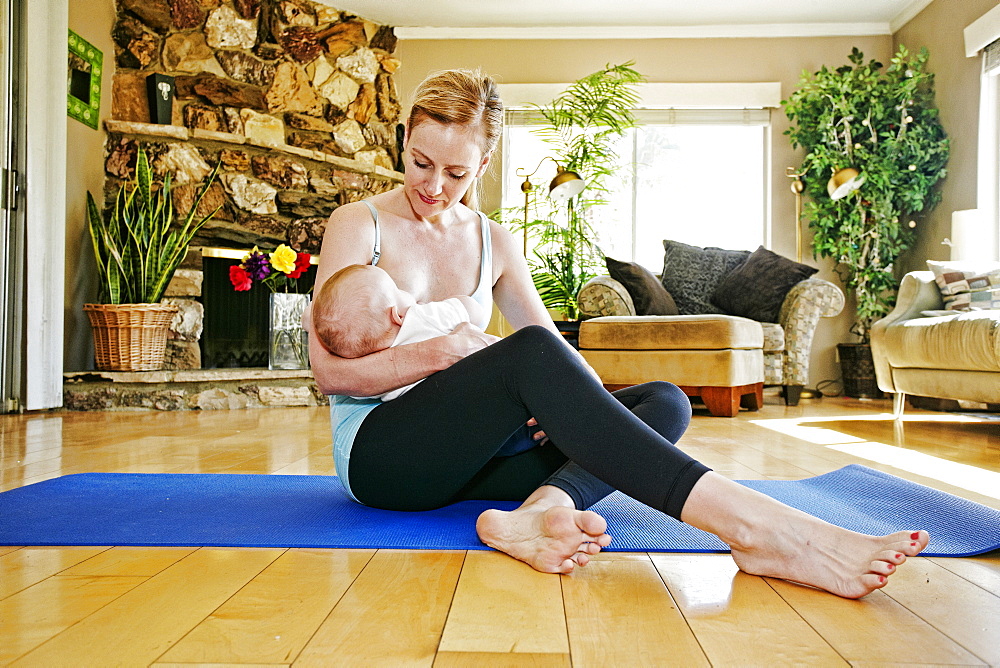 Mother resting from working out breastfeeding baby