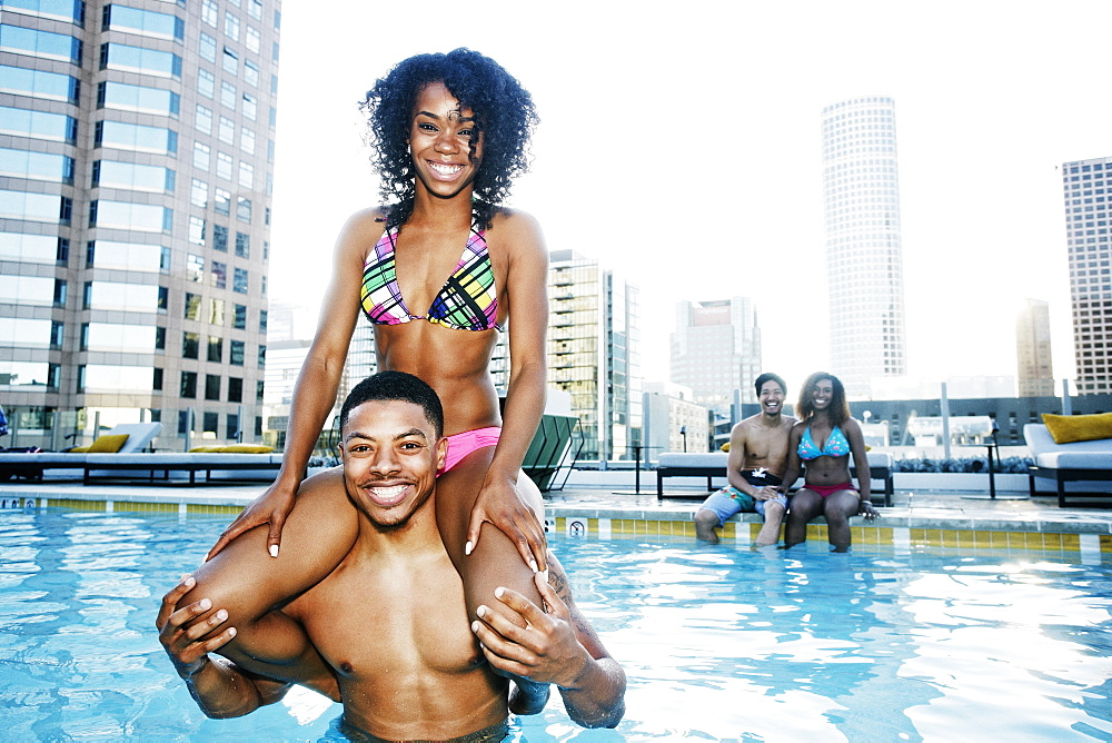 Smiling friends enjoying urban swimming pool