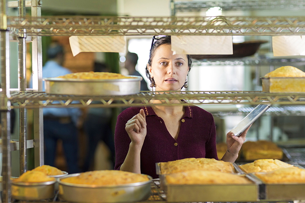 Caucasian woman using digital tablet in bakery