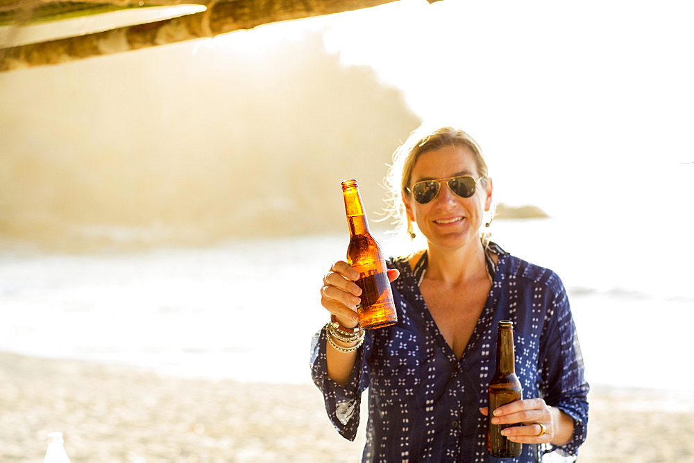 Caucasian woman holding two bottles of beer