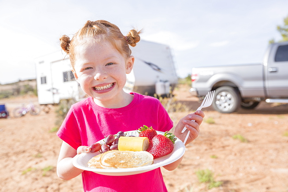 Caucasian girl posing with breakfast plate