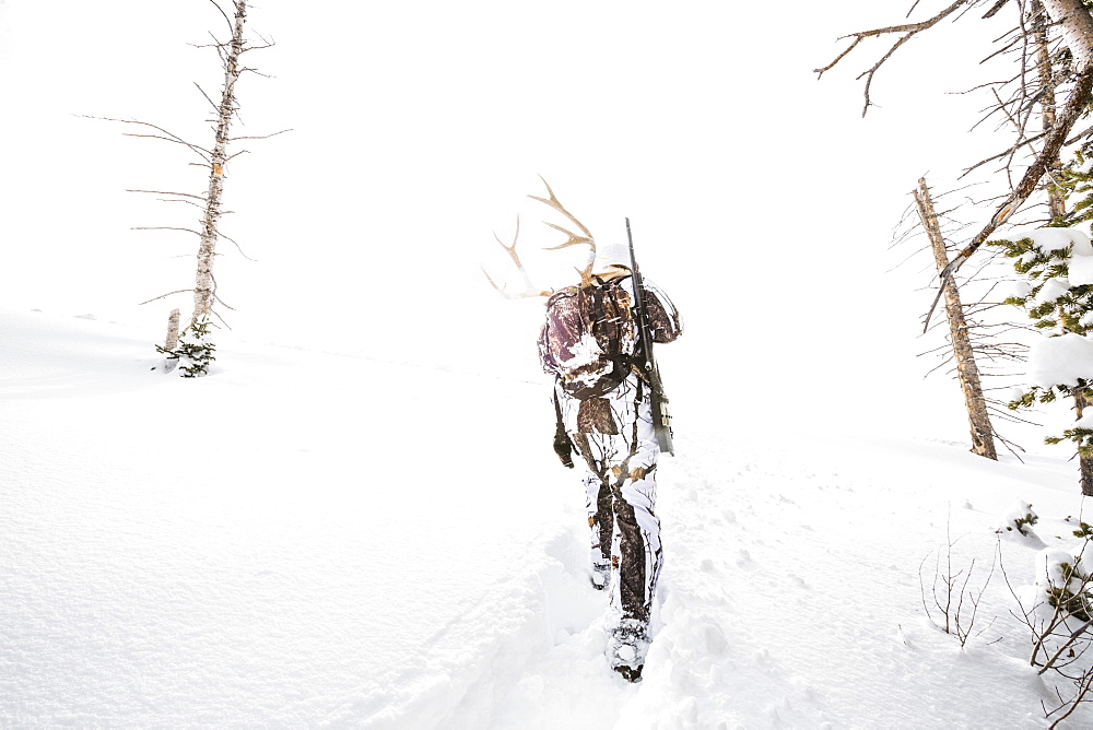 Caucasian woman hunting in forest carrying antlers