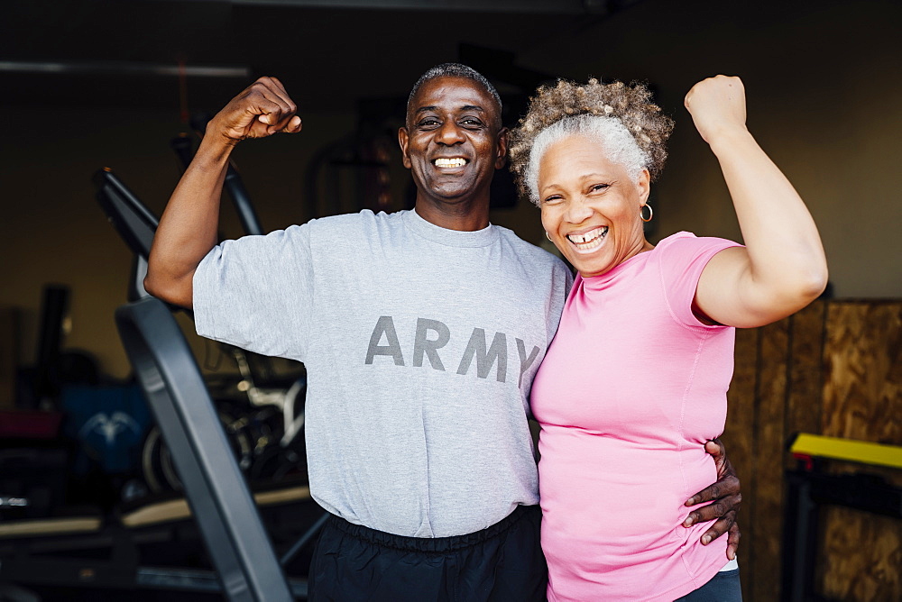 Black woman flexing muscles in garage