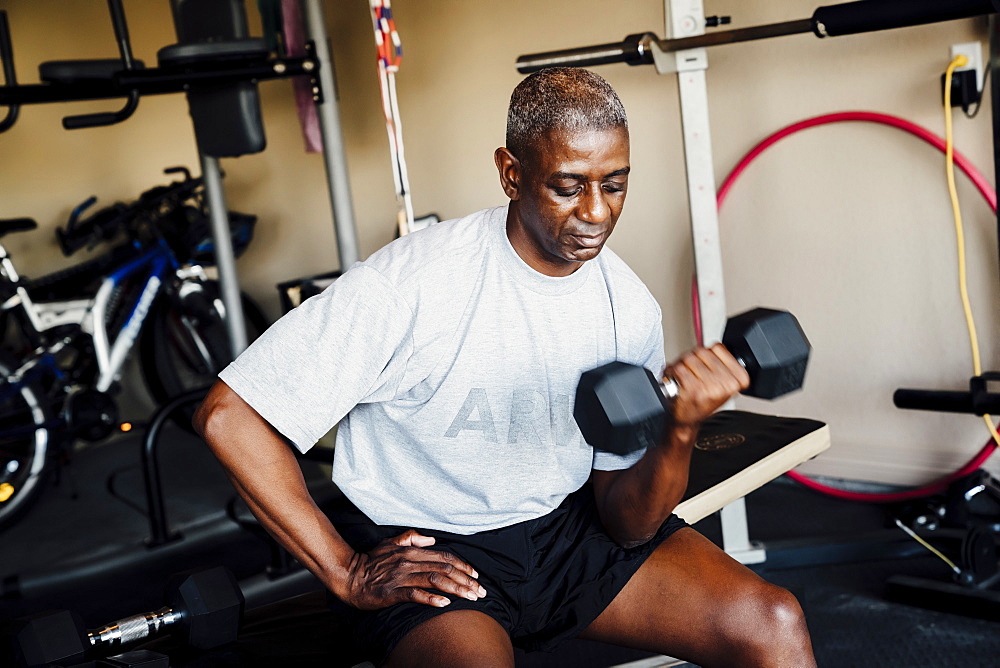 Black woman lifting weights in garage