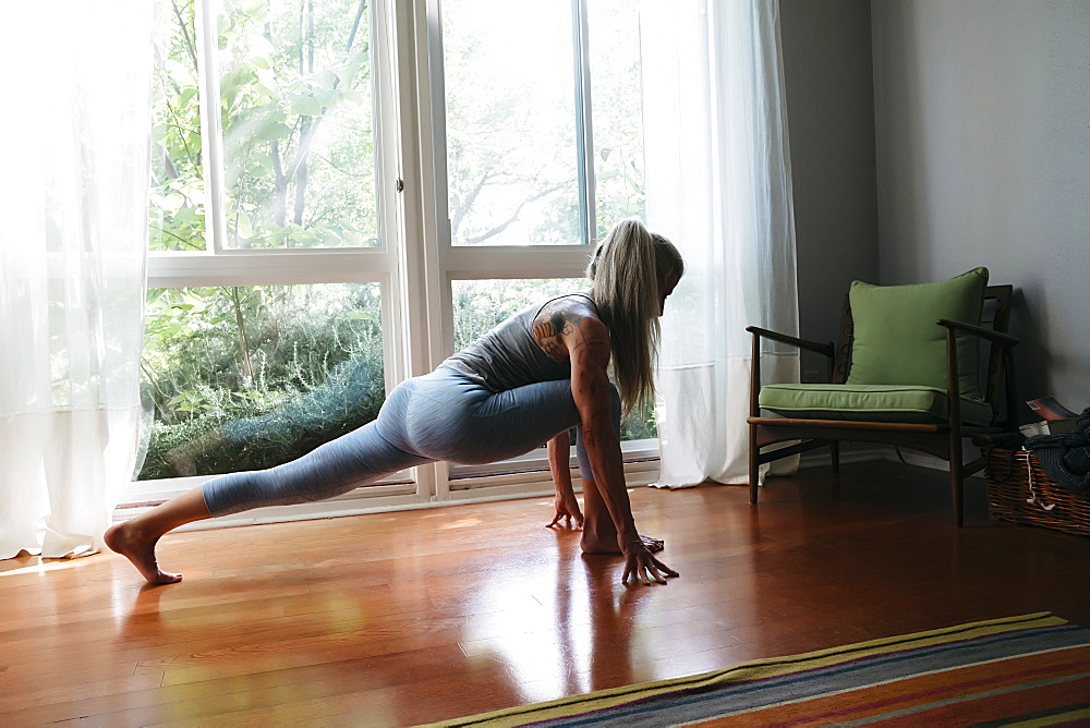 Caucasian woman stretching leg on floor