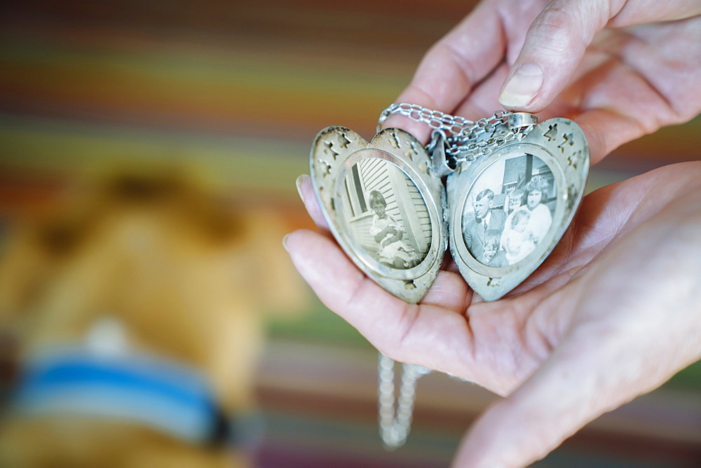 Hands of Caucasian woman showing photographs in cameo