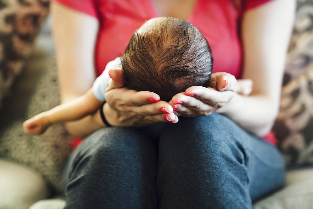 Hispanic woman holding baby boy in lap