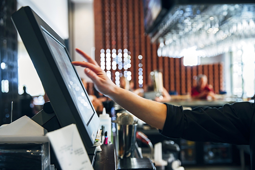 Caucasian bartender using computer