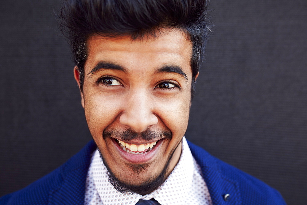 Smiling Middle Eastern man wearing jacket and tie