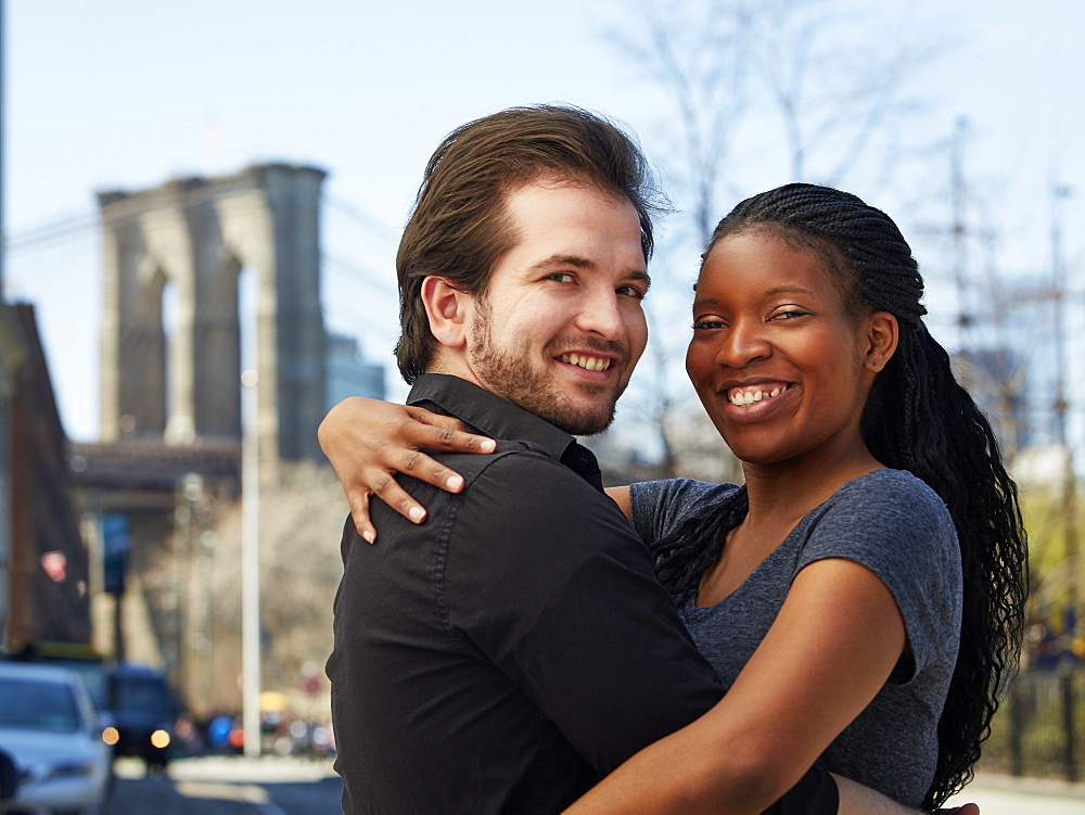 Smiling couple hugging in city