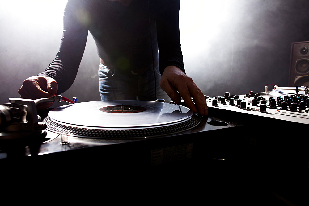 Caucasian disc jockey playing music in nightclub