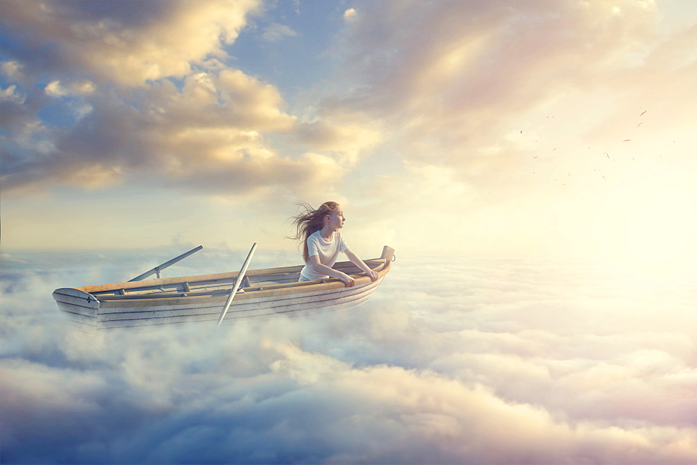 Caucasian girl sitting in rowboat in clouds