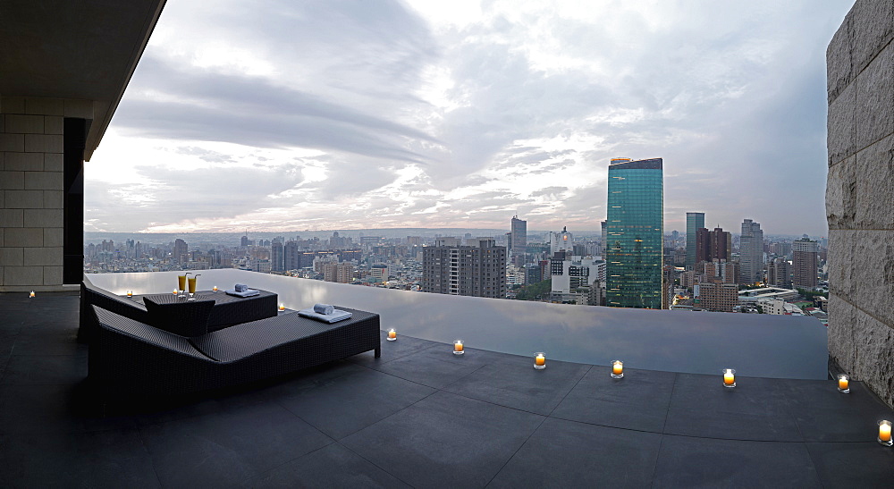 Two lounge chairs on outdoor terrace overlooking city