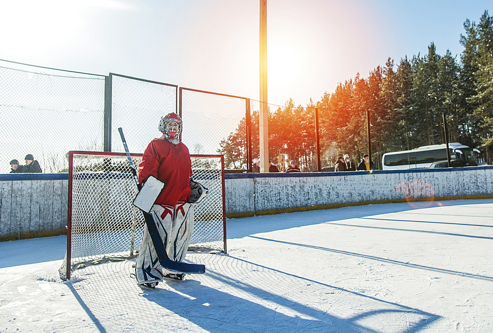 Caucasian boy playing goalie in ice hockey outdoors