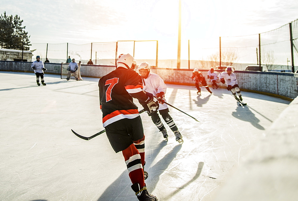 Caucasian boys playing ice hockey outdoors