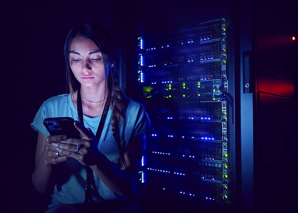 Technician using smart phone in server room