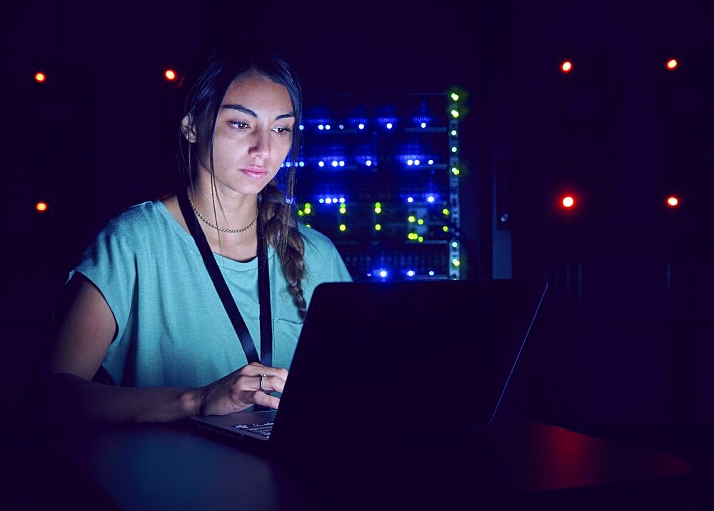 Technician using laptop in server room