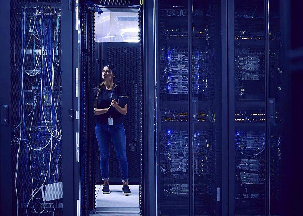 Female technician working in server room