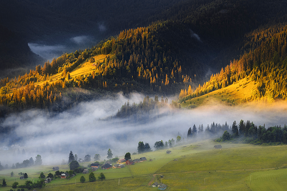 Ukraine, Ivano Frankivsk region, Verkhovyna district, Dzembronya village, Foggy rolling landscape in Carpathian Mountains at sunset