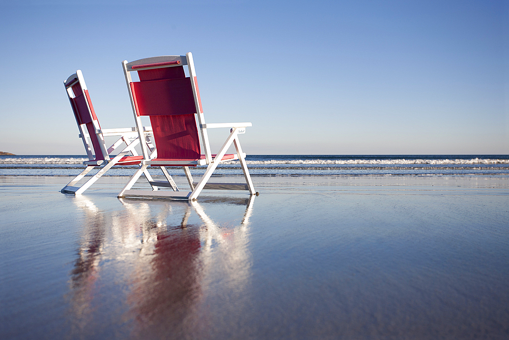 USA, Maine, York, Two beach chairs on wet sand beach