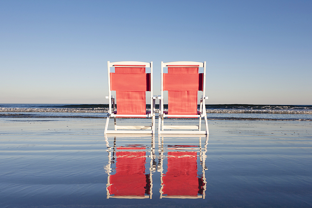 USA, Maine, York, Two beach chairs on wet sand beach