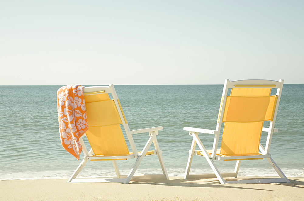 USA, Massachusetts, Nantucket, Two yellow beach chairs on sandy beach facing ocean
