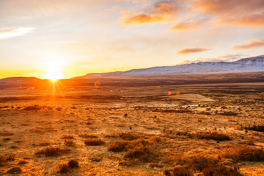 Argentina, Santa Cruz, El Calafate, Sun rising above plain landscape with mountains in distance