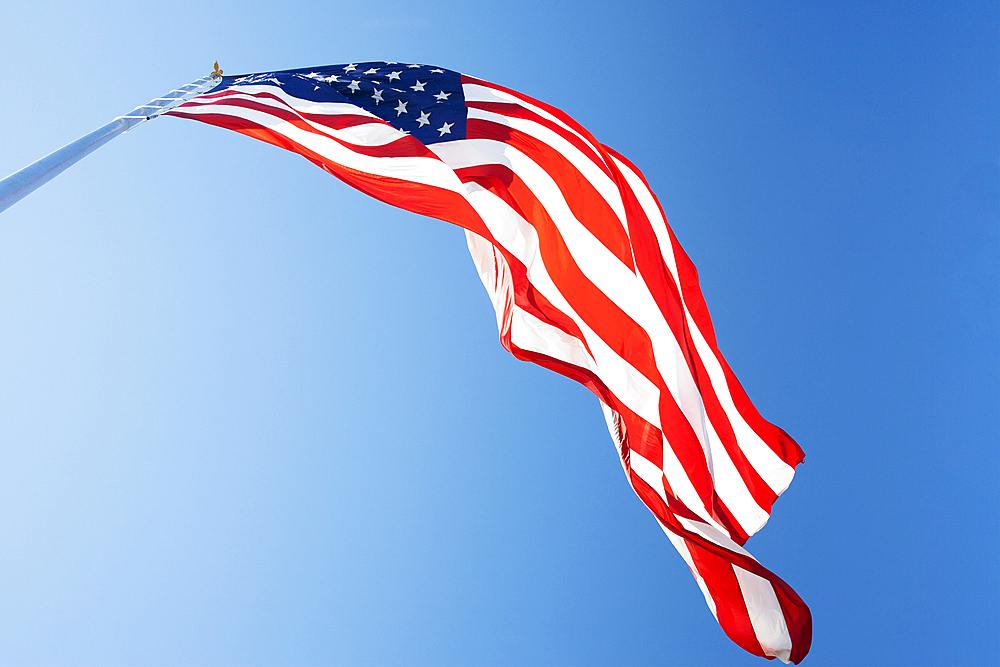 Ow angle view of American Flag against blue sky