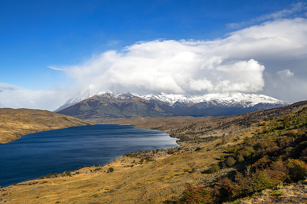 Clouds over lake and peaks of Torres Del Paine in sunlight