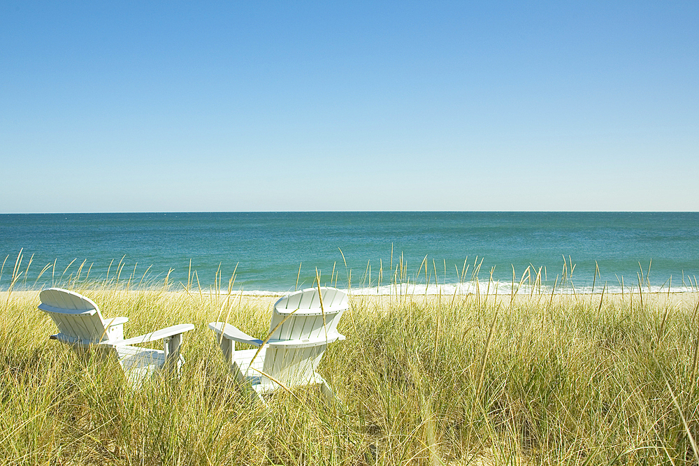 Pair of Adirondack chairs by beach