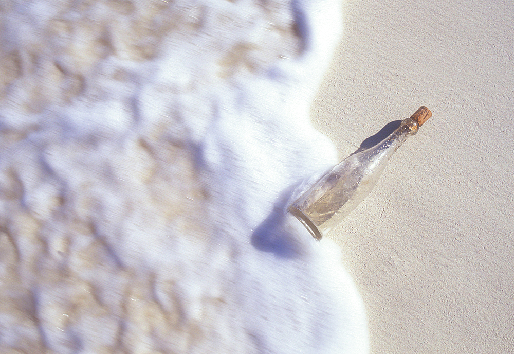 Message in a bottle washing onto beach