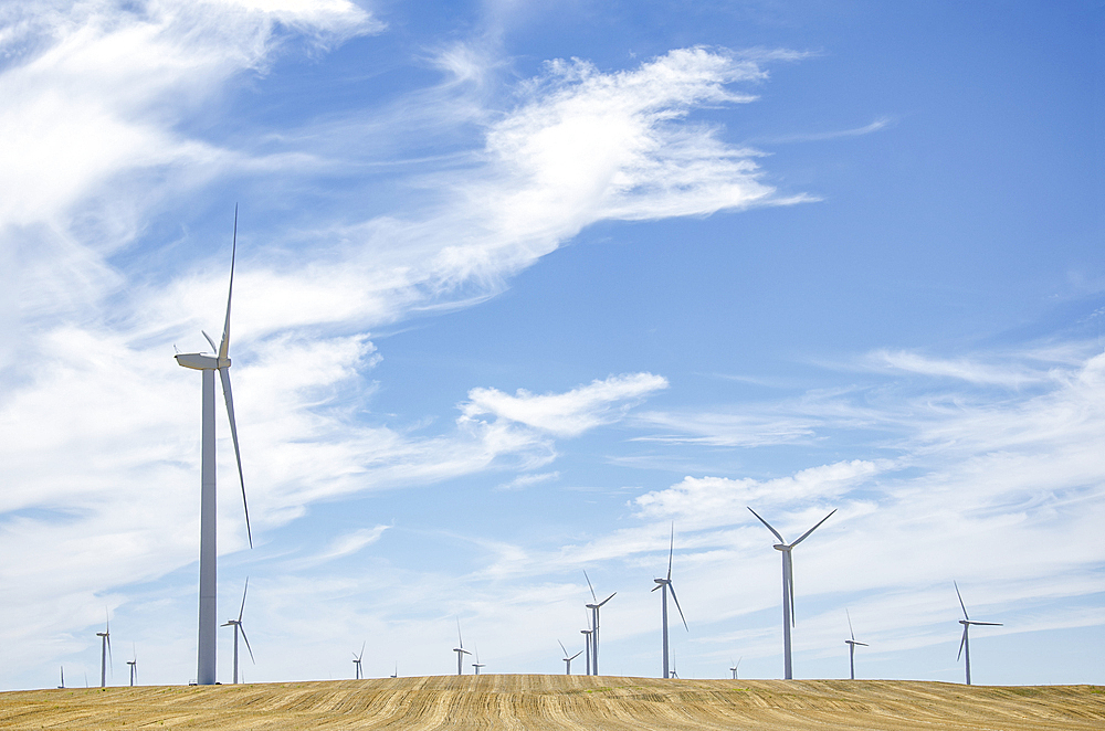 Wispy clouds on sky above wind farm, California, USA