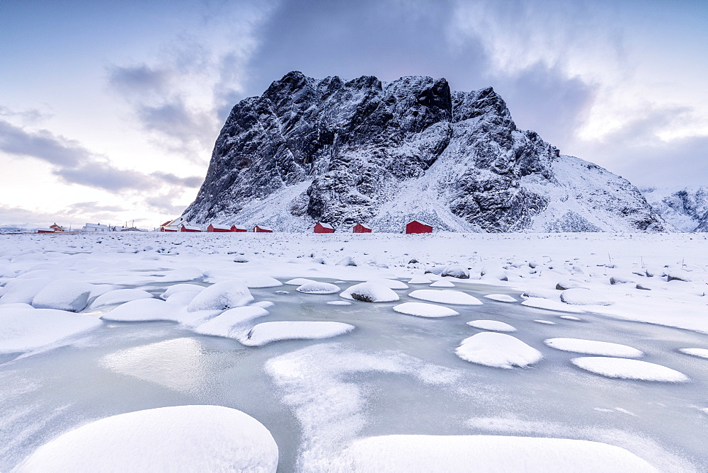 Snowy peaks and ice frame the typical fishermen houses called Rorbu, Eggum, Vestvagoy (Vest-Vagoy) Island, Lofoten Islands, Arctic, Norway, Scandinavia, Europe