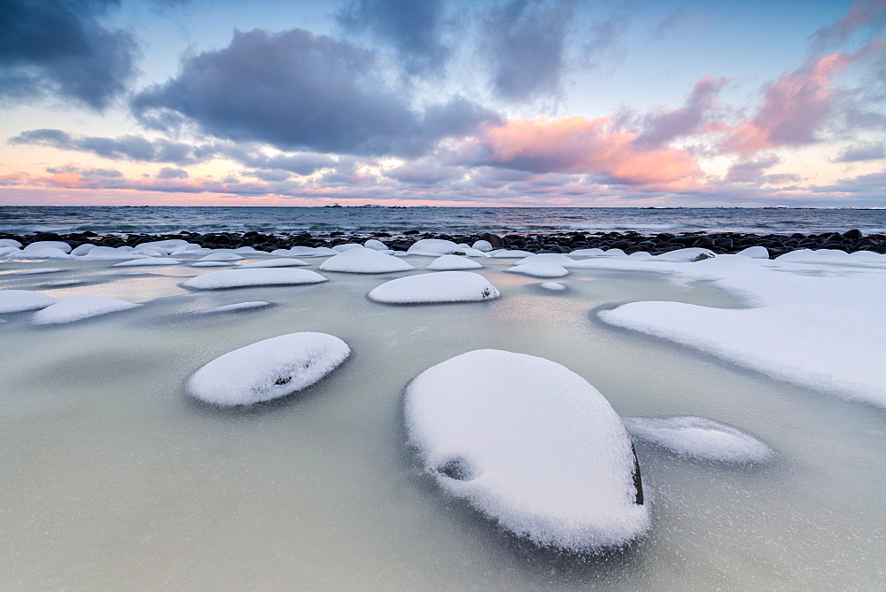 Dawn on the cold sea surrounded by snowy  rocks shaped by wind and ice at Eggum, Vestvagoy (Vest-Vagoy) Island, Lofoten Islands, Arctic, Norway, Scandinavia, Europe