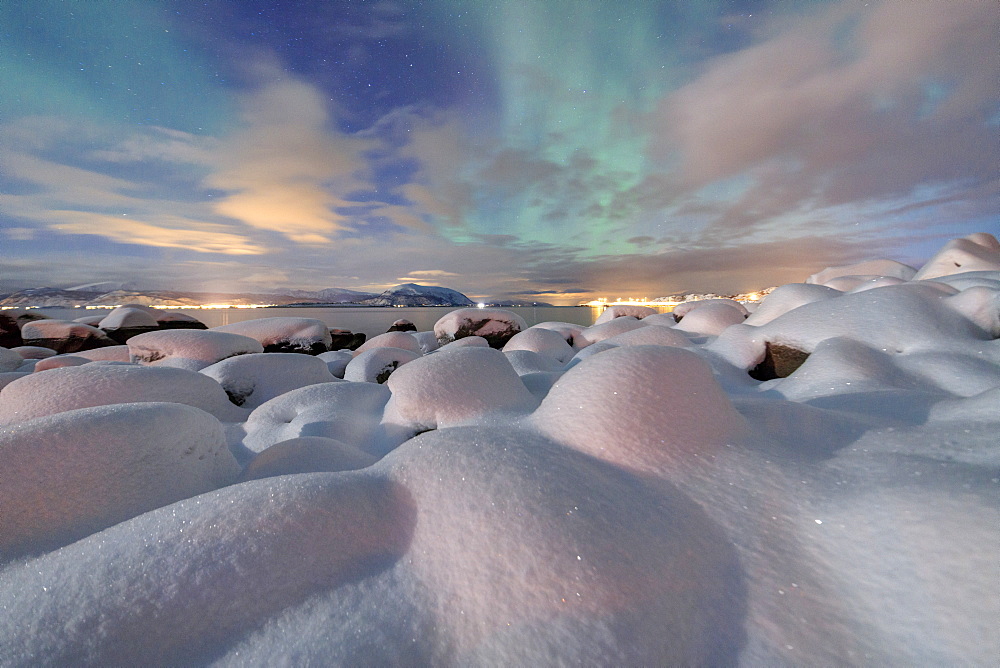 The pink light and the aurora borealis (Northern Lights) illuminate the snowy landscape on a starry night Stronstad, Lofoten Islands, Arctic, Norway Scandinavia, Europe