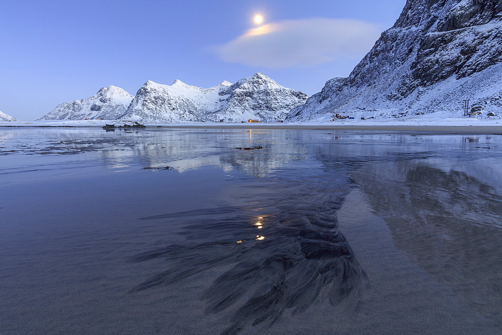 Full moon reflected in the icy sea around the surreal Skagsanden beach, Flakstad, Nordland county, Lofoten Islands, Arctic, Norway, Scandinavia, Europe