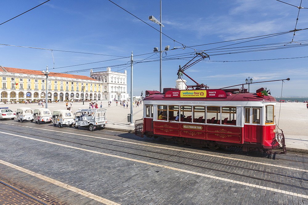 A typical red tram stops at the historical Praca Do Comercio square near the Tagus river, Lisbon, Estremadura, Portugal, Europe