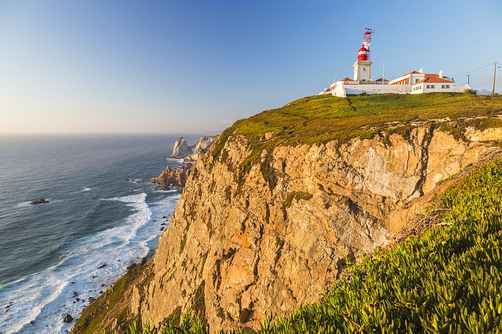 The Cabo da Roca lighthouse overlooks the promontory towards the Atlantic Ocean at sunset, Sintra, Portugal, Europe