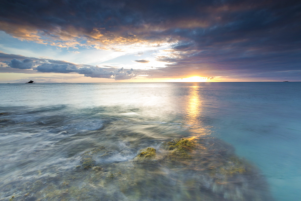 The lights of sunset are reflected in the blue sea, Hawksbill Bay, Antigua, Antigua and Barbuda, Leeward Islands, West Indies, Caribbean, Central America