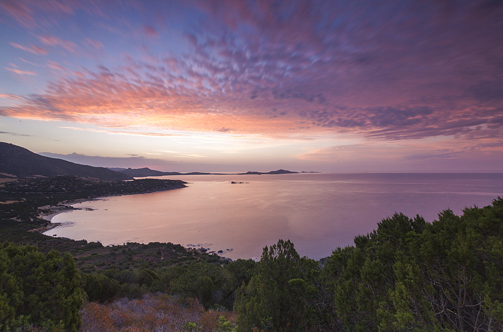 The colors of sunrise are reflected on the sea around the beach of Solanas, Villasimius, Cagliari, Sardinia, Italy, Mediterranean, Europe