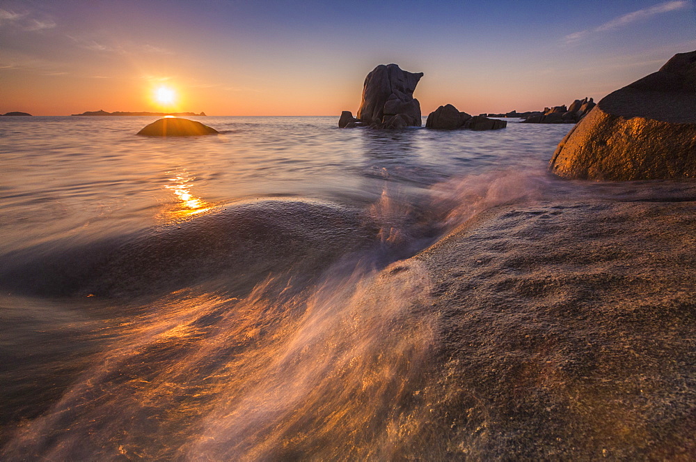 Waves crashing on cliffs under the fiery sky at sunrise, Punta Molentis, Villasimius, Cagliari, Sardinia, Italy, Mediterranean, Europe